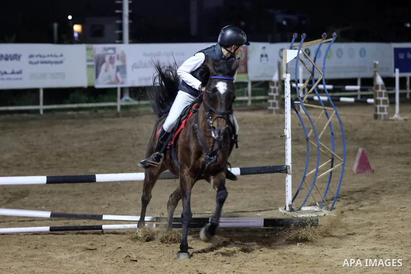 A Palestinian horse rider on his horse jumps over a barrier during the first championship in jump barriers for the year 2020, on February 27, 2020. Photo by Mahmoud Ajjour