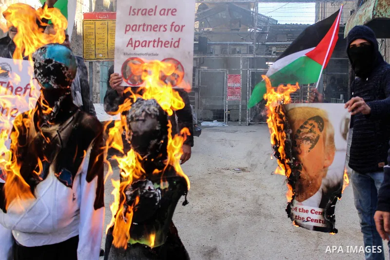 Palestinian protesters burn the effigies depicting U.S. President Donald Trump and Israeli Prime Minister Benjamin Netanyaho in the West Bank city of Hebron, on February 28, 2020. Photo by Mosab Shawer