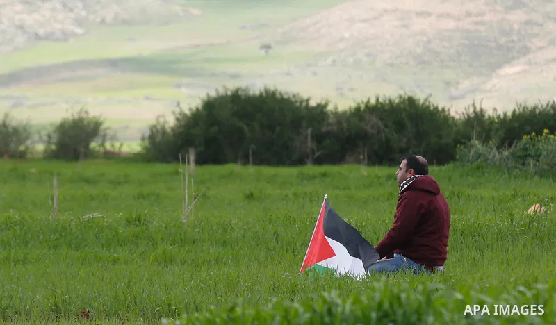 A Palestinian man holds a flag during a protest against the expropriation of Palestinian land, in the West Bank city of Tubas, on February 29, 2020. The village of Khirbet Makhoul is a closed military zone "C". Israel pl...