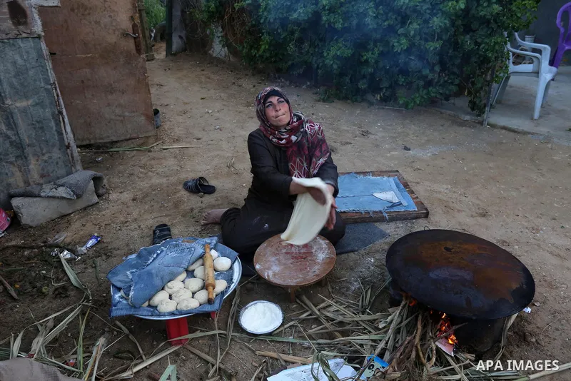 Palestinian woman Sahar Abu Raida, 45, bakes al-Taboun inside her house, in Khan Yunis in the southern Gaza Strip on March 8, 2020. International Women's Day (IWD) is celebrated on the 8th of March every year around the...