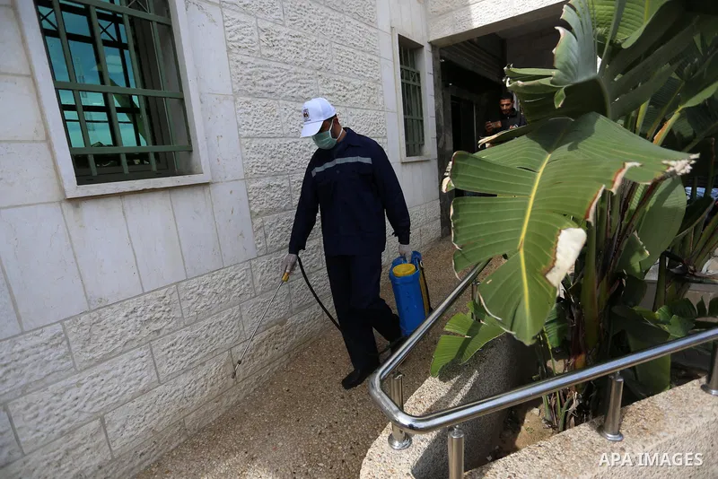 A Palestinian worker disinfects a municipal building, as a preventive measure amid fears of the spread of the novel coronavirus, in Khan Younis in the southern Gaza Strip on March 9, 2020. Photo by Ashraf Amra