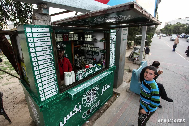 Palestinian Mohammed al-Nimr, 21, sells hot drinks on his Starbucks cart, in Gaza City on March 11, 2020. Starbucks Corporation is an American coffee company and coffeehouse chain. Starbucks was founded in Seattle, Washi...
