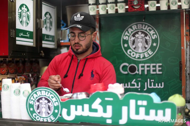 Palestinian Mohammed al-Nimr, 21, sells hot drinks on his Starbucks cart, in Gaza City on March 11, 2020. Starbucks Corporation is an American coffee company and coffeehouse chain. Starbucks was founded in Seattle, Washi...