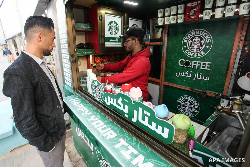 Palestinian Mohammed al-Nimr, 21, sells hot drinks on his Starbucks cart, in Gaza City on March 11, 2020. Starbucks Corporation is an American coffee company and coffeehouse chain. Starbucks was founded in Seattle, Washi...
