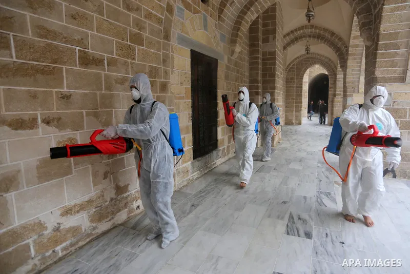 Palestinian workers disinfect Al-Omari Mosque, as a preventive measure amid fears of the spread of the novel coronavirus, in Gaza City on March 12, 2020. Photo by Ashraf Amra