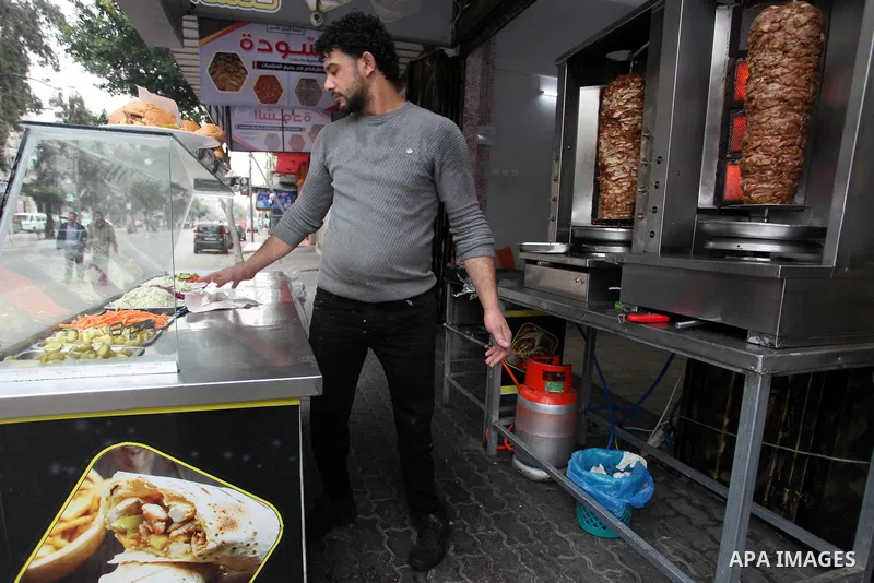 Palestinian wounded Adham Al-Tahrawi, who lost his leg after shotting him by Israeli forces during the weekly border protests, sells shawarma in a restaurant in Gaza City, March 13, 2020. The Palestinian Day of the Wound...