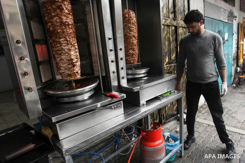 Palestinian wounded Adham Al-Tahrawi, who lost his leg after shotting him by Israeli forces during the weekly border protests, sells shawarma in a restaurant in Gaza City, March 13, 2020. The Palestinian Day of the Wound...