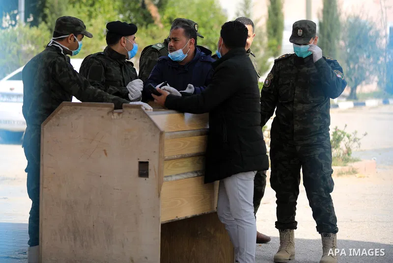Palestinian policemen wearing masks as a means of protection against the coronavirus COVID-19, stand outside the gate of Erez crossing with Israel in Beit Hanoun in the northern Gaza Strip on March 15, 2020. Palestinian...