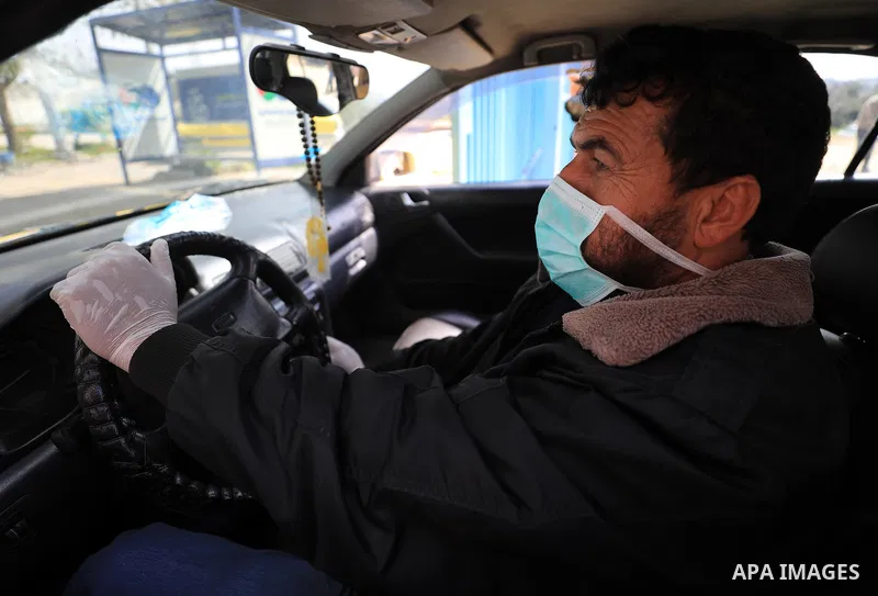 A Palestinian man wearing a mask as a means of protection against the coronavirus COVID-19, stand outside the gate of Erez crossing with Israel in Beit Hanoun in the northern Gaza Strip on March 15, 2020. Palestinian gov...