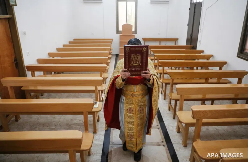 A Palestinian Christian prays at the church in the West Bank city of Jenin on March 15, 2020. For most people, the new coronavirus causes only mild or moderate symptoms. For some it can cause more severe illness. Photo b...