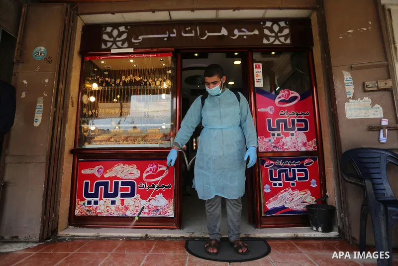 A Palestinian worker wearing protective gear, disinfects streets, as a preventive measure amid fears of the spread of the coronavirus COVID-19, at al-shati' refugee camp in Gaza City on March 16, 2020. Photo by Ashraf Am...