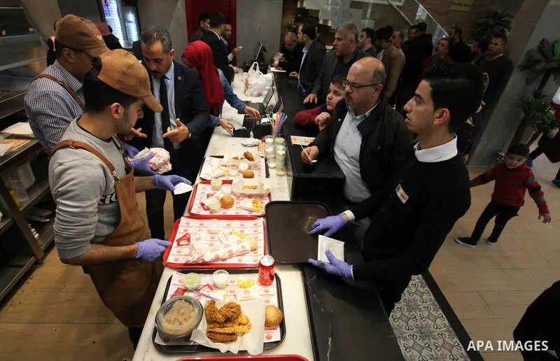 Palestinian youth serve the fast food for customers, at the Chicken Broast in Gaza City, on March 16, 2020. Chicken Broast is a restaurant located in Egypt, serving a selection of Sandwiches that delivers across Miami -...