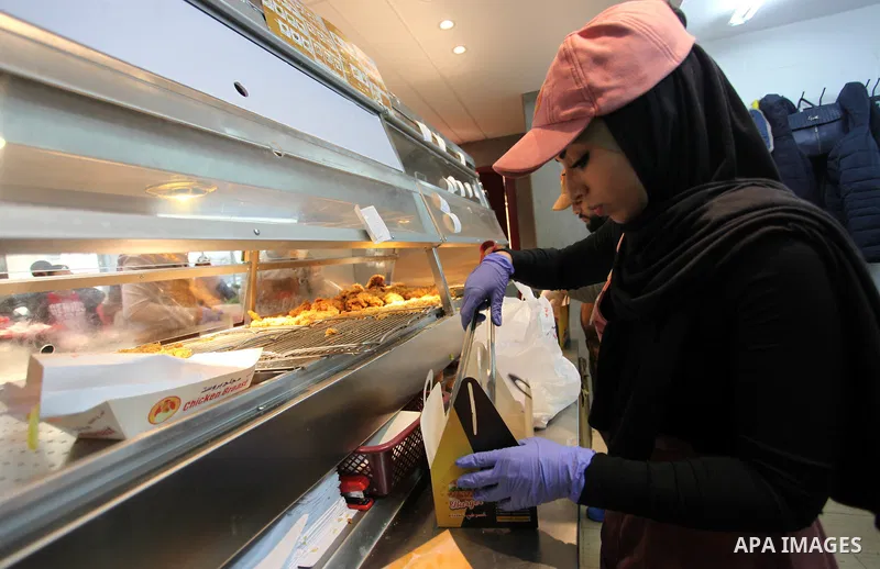 Palestinian youth serve the fast food for customers, at the Chicken Broast in Gaza City, on March 16, 2020. Chicken Broast is a restaurant located in Egypt, serving a selection of Sandwiches that delivers across Miami -...