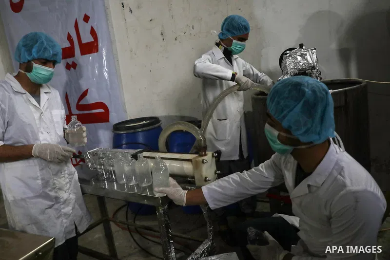 Palestinian factory workers work in the manufacture of disinfectants on a production line at a chemical agent production facility in Gaza City, on March 17, 2020. Production of disinfectants in factories has increased re...