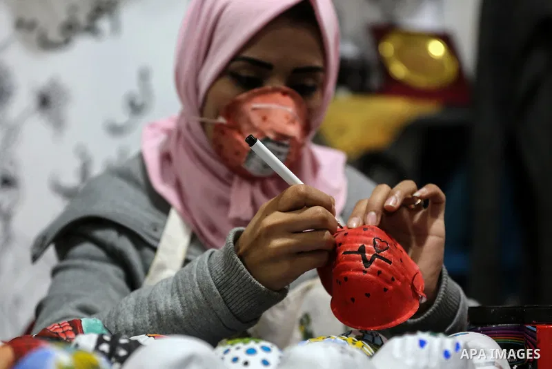 Palestinian artists Samah Said and Dorgham Krakeh paint N95 protective masks for a project raising awareness about the coronavirus COVID-19, in Gaza City on March 25, 2020. Production of face masks in factories has incre...