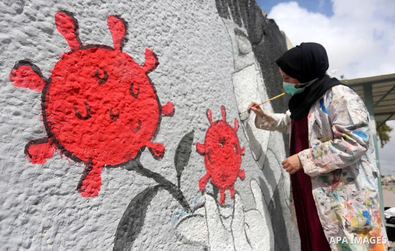Palestinian artists draw a mural during awareness campaign about the coronavirus COVID-19, in Khan Younis in the southern of Gaza Strip on March 28, 2020. Photo by Ashraf Amra