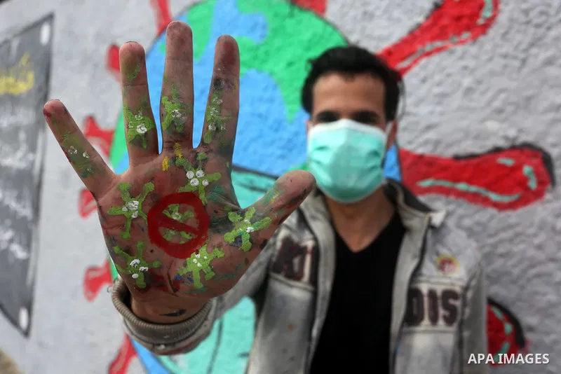 Palestinian artists draw a mural during awareness campaign about the coronavirus COVID-19, in Khan Younis in the southern of Gaza Strip on March 28, 2020. Photo by Ashraf Amra