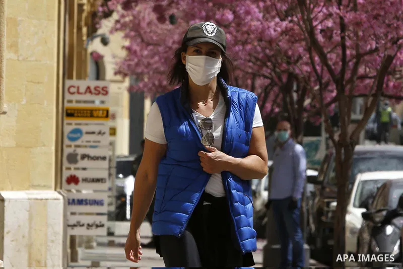 Lebanese woman wearing a mask as a means of protection against the coronavirus COVID-19, walks in Beirut, Lebanon, on March 31, 2020. Photo by Marwan Tahtah