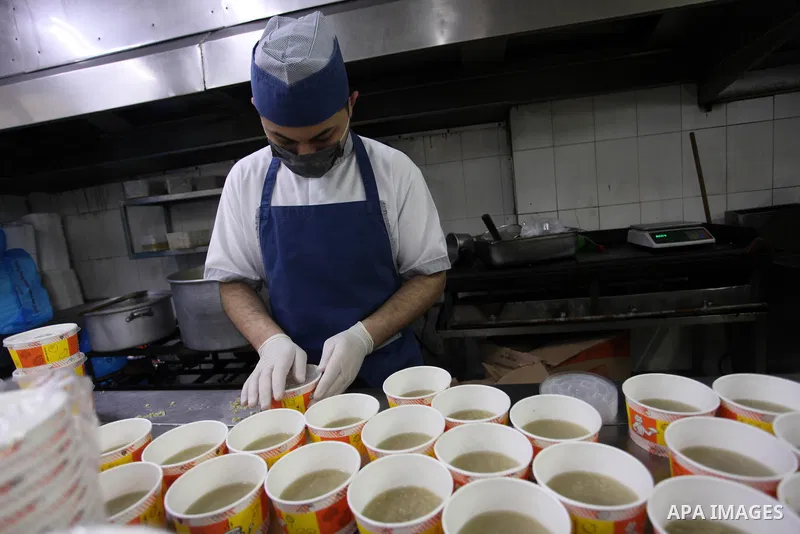 Palestinian chefs wearing protective masks, prepare meals for breakfast on holy fasting month of Ramadan for people who were quarantined, as a precaution against the spread of the coronavirus disease (COVID-19), at a res...