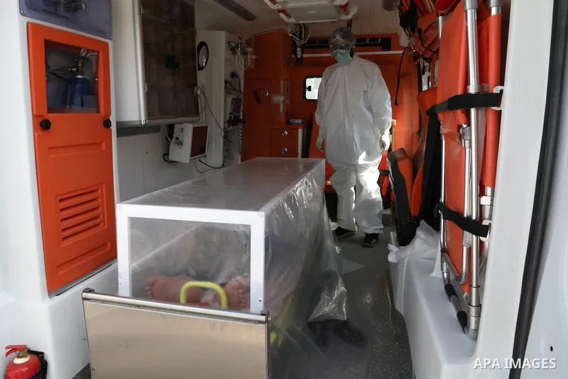 A photo taken on April 9, 2020, shows Syrian doctors put on a protective suits examine sample from a patient at the Mobile test center for suspected coronavirus outside the National Hospital in the northern Syrian city o...