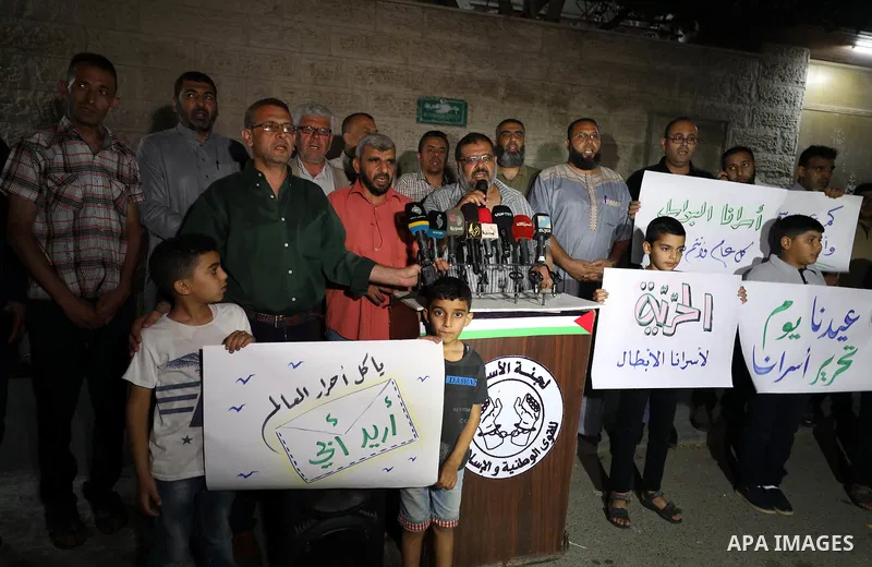 Palestinians hold banners during a protest to solidarity with prisoners held in israeli jails, ahead of Eid al-Fitr holiday in front of Red cross office in Gaza City, on May 23, 2020. Photo by Mahmoud Nasar