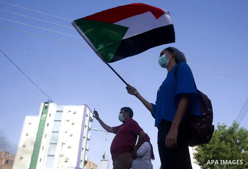 Sudanese protesters some clad in masks as a precaution due to the COVID-19 coronavirus pandemic, wave national flags and burn tyres as they take part in a demonstration in the capital Khartoum, on May 23, 2020. Scores of...