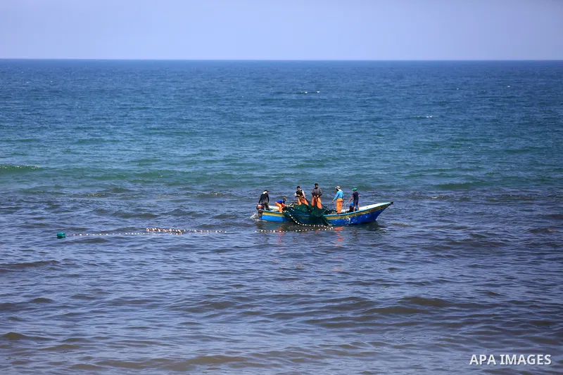 Palestinian fishermen cast a net to catch fishes on a sunny day in the coastal areas, in Gaza City on June 27, 2020. Photo by Ashraf Amra