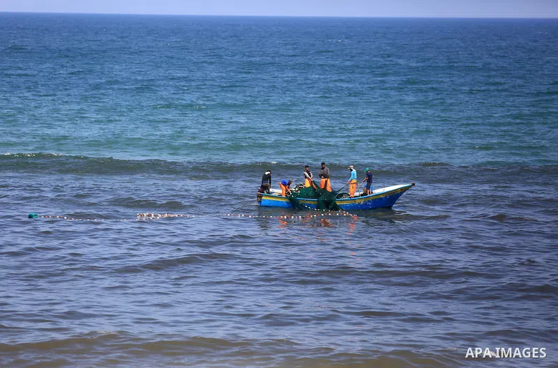 Palestinian fishermen cast a net to catch fishes on a sunny day in the coastal areas, in Gaza City on June 27, 2020. Photo by Ashraf Amra