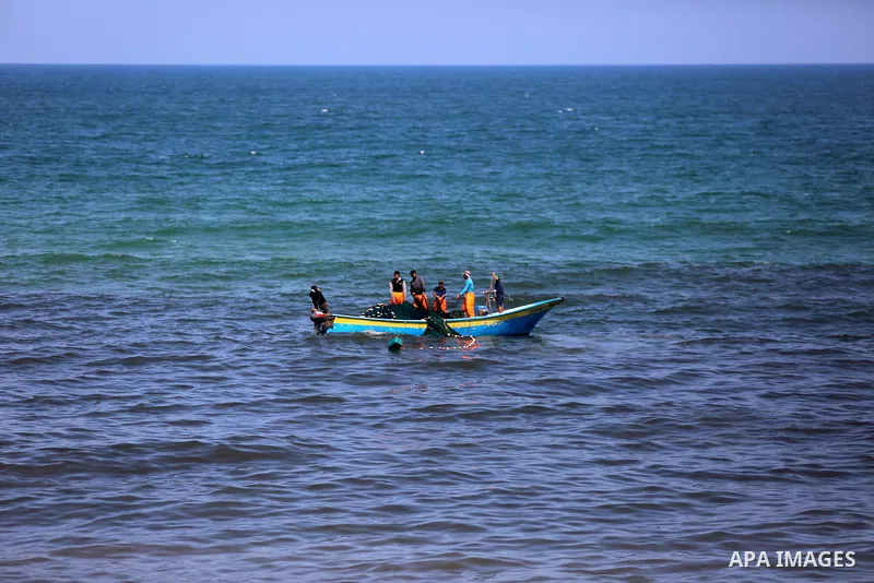 Palestinian fishermen cast a net to catch fishes on a sunny day in the coastal areas, in Gaza City on June 27, 2020. Photo by Ashraf Amra