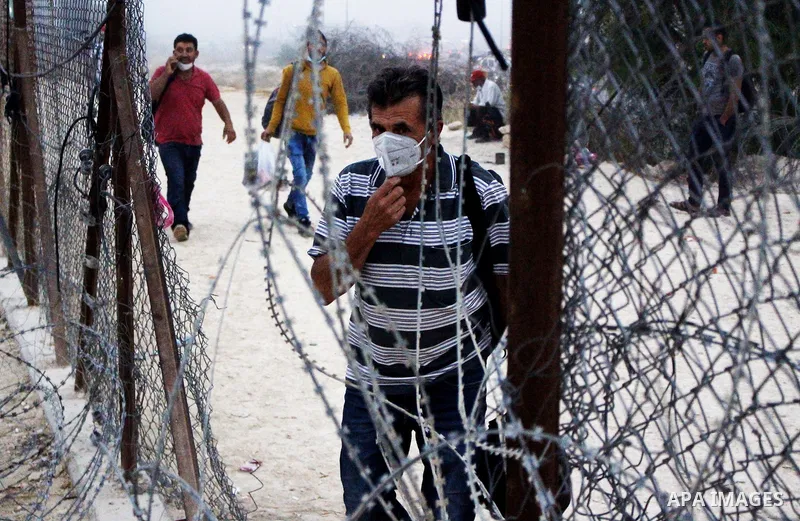 Palestinian labourers wear masks queue to enter Israel through the Mitar checkpoint in the West Bank city of Hebron on June 28, 2020. Photo by Mosab Shawer