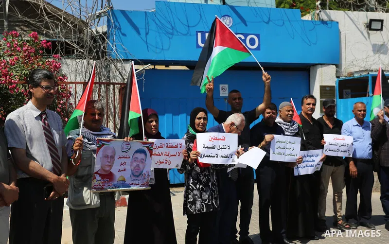 Palestinians take part in a protest against Israel's plan to annex parts of the occupied territory and against US President Donald Trump's Century Deal "expected peace plan", in front of the headquarter United Nation "UN...