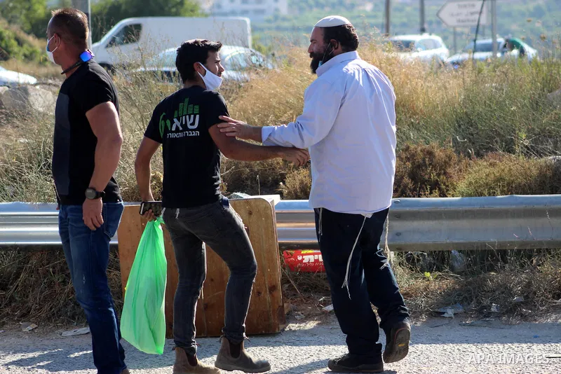 Israeli security forces stand guard as settlers gathern in the mountain of Aljomjoma in the city of Halhul, north of the West Bank of Hebron on June 30, 2020. Photo by Mosab Shawer