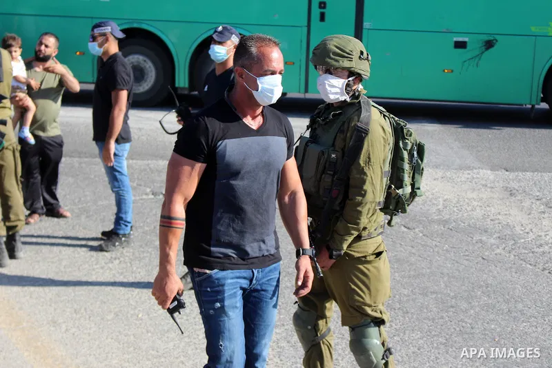 Israeli security forces stand guard as settlers gathern in the mountain of Aljomjoma in the city of Halhul, north of the West Bank of Hebron on June 30, 2020. Photo by Mosab Shawer