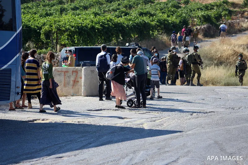 Israeli security forces stand guard as settlers gathern in the mountain of Aljomjoma in the city of Halhul, north of the West Bank of Hebron on June 30, 2020. Photo by Mosab Shawer