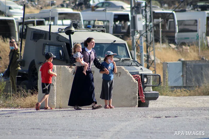 Israeli security forces stand guard as settlers gathern in the mountain of Aljomjoma in the city of Halhul, north of the West Bank of Hebron on June 30, 2020. Photo by Mosab Shawer