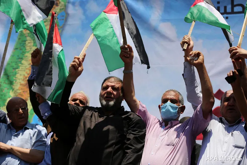Palestinians hold placards and national flags during a demonstration against Israel's West Bank annexation plans in Gaza City on July 1, 2020. Israel's Prime Minister Benjamin Netanyahu, emboldened by the US Mideast plan...
