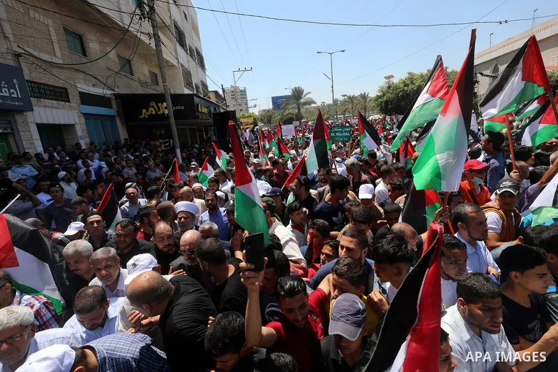 Palestinians hold placards and national flags during a demonstration against Israel's West Bank annexation plans in Gaza City on July 1, 2020. Israel's Prime Minister Benjamin Netanyahu, emboldened by the US Mideast plan...