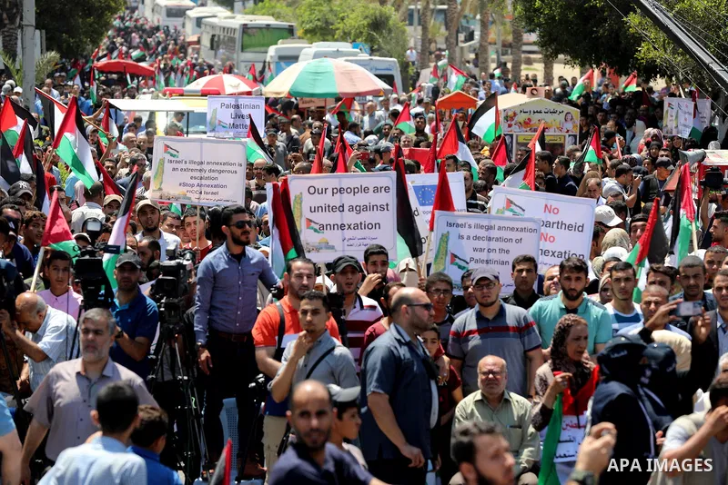 Palestinians hold placards and national flags during a demonstration against Israel's West Bank annexation plans in Gaza City on July 1, 2020. Israel's Prime Minister Benjamin Netanyahu, emboldened by the US Mideast plan...