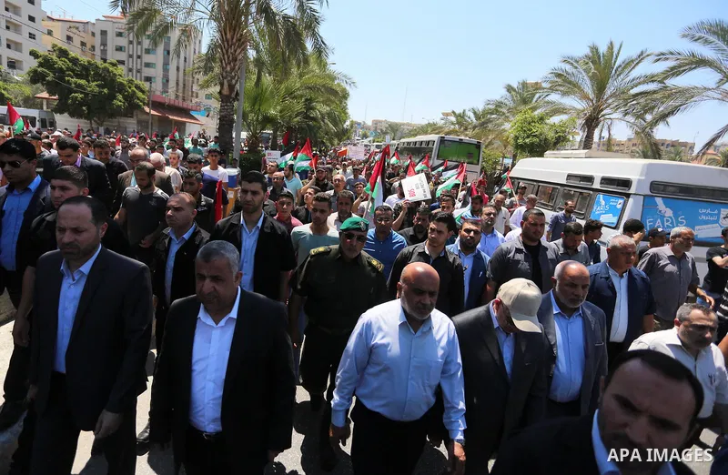 Palestinians hold placards and national flags during a demonstration against Israel's West Bank annexation plans in Gaza City on July 1, 2020. Israel's Prime Minister Benjamin Netanyahu, emboldened by the US Mideast plan...