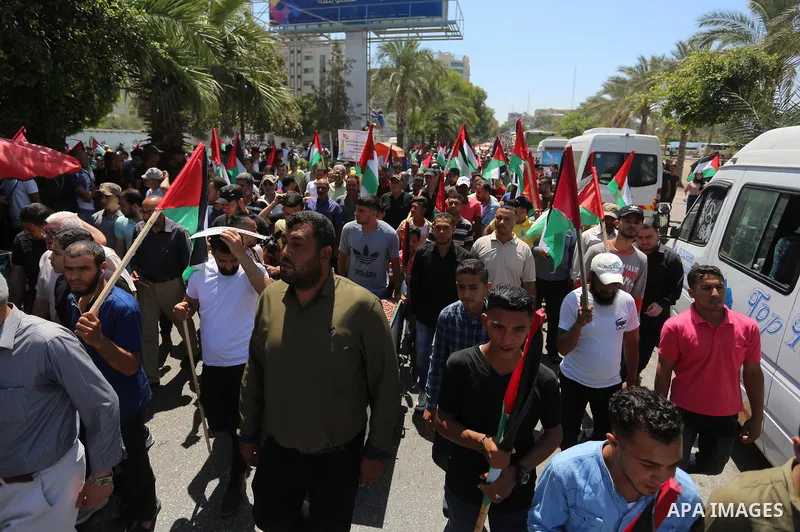Palestinians hold placards and national flags during a demonstration against Israel's West Bank annexation plans in Gaza City on July 1, 2020. Israel's Prime Minister Benjamin Netanyahu, emboldened by the US Mideast plan...