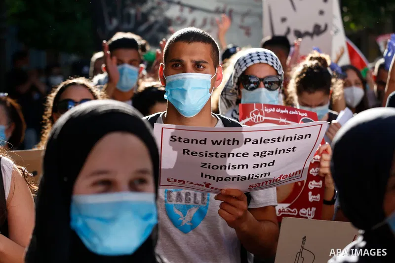 Palestinians hold placards and national flags during a demonstration against Israel's West Bank annexation plans in the West Bank city of Ramallah on July 1, 2020. Israel's Prime Minister Benjamin Netanyahu, emboldened b...
