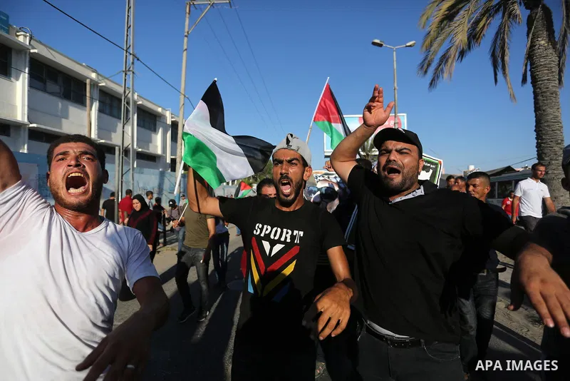 Palestinians waves national flags and hold posters of Palestinian President Mahmud Abbas during a demonstration against Israel's West Bank annexation plans in Khan Younis in the southern Gaza Strip, on July 2, 2020. Isra...