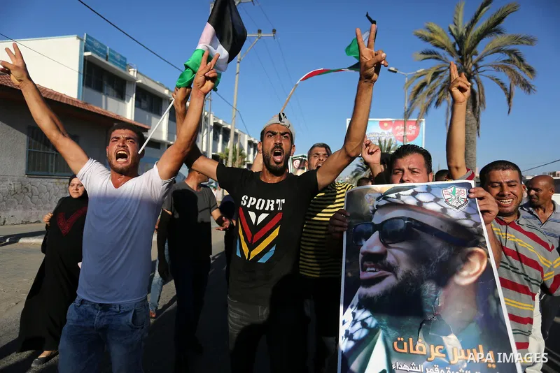 Palestinians waves national flags and hold posters of Palestinian President Mahmud Abbas during a demonstration against Israel's West Bank annexation plans in Khan Younis in the southern Gaza Strip, on July 2, 2020. Isra...