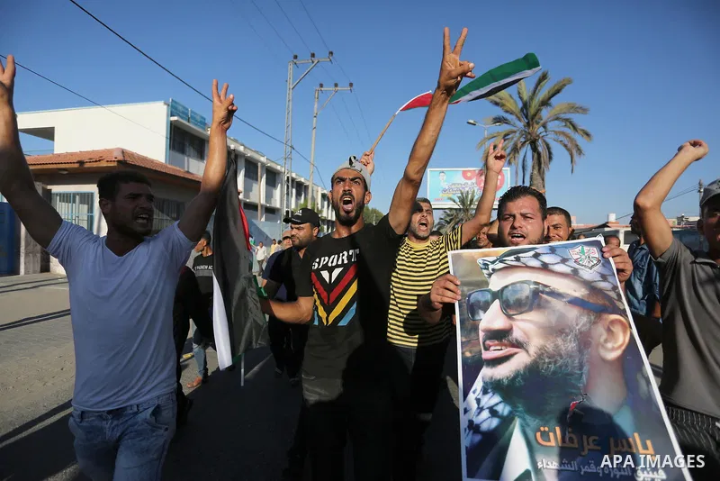 Palestinians waves national flags and hold posters of Palestinian President Mahmud Abbas during a demonstration against Israel's West Bank annexation plans in Khan Younis in the southern Gaza Strip, on July 2, 2020. Isra...