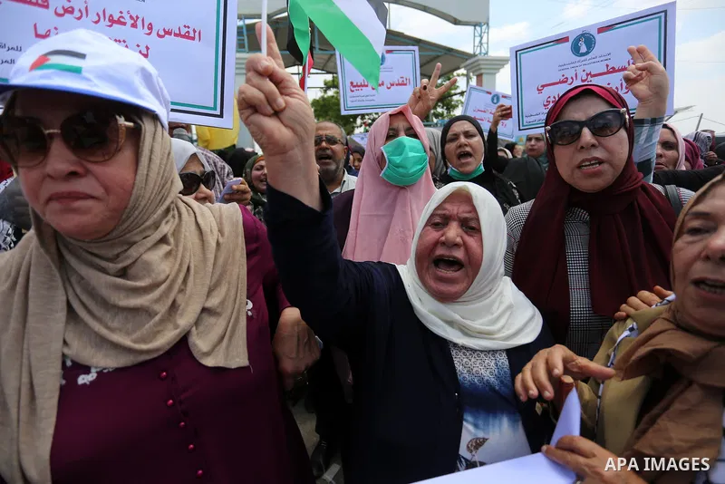 Palestinian women hold placards and national flags during a demonstration against Israel's West Bank annexation plans in front of the gate of Erez crossing with Israel in Beit Hanoun in the northern Gaza Strip, on July 6...