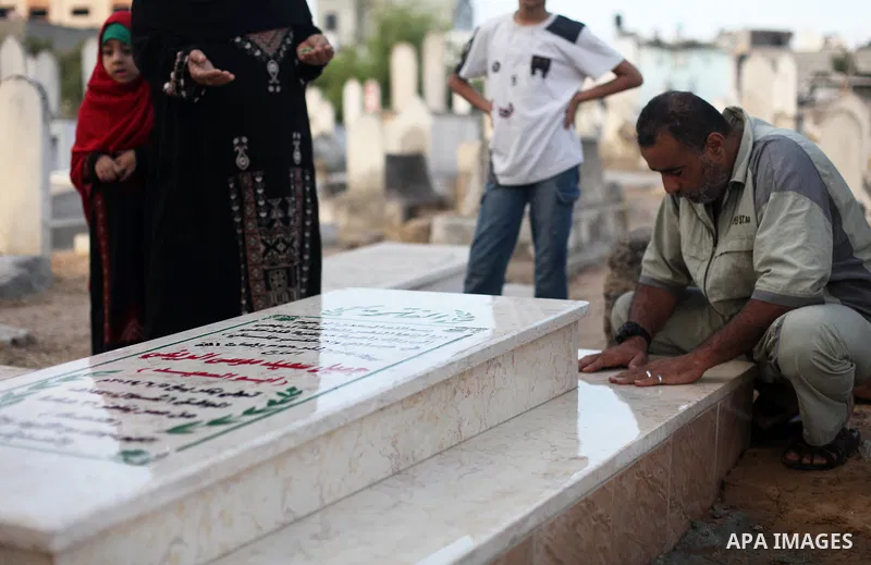 Palestinians visit the graves of their relatives during the Eid al-Adha festival at a cemetery in Gaza city on July 31, 2020. Muslims are celebrating Eid al-Adha (the feast of sacrifice), the second of two Islamic holida...