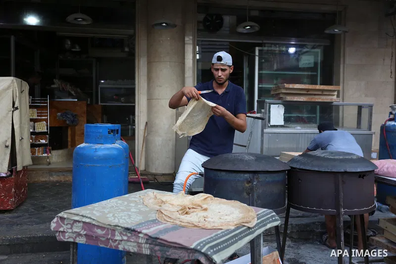 Palestinian men bake a traditional bread "Taboon" on the first day of Eid al-Adha or feast of the sacrifice, in Gaza city on July 31, 2020. Muslims are celebrating Eid al-Adha (the feast of sacrifice), the second of two...
