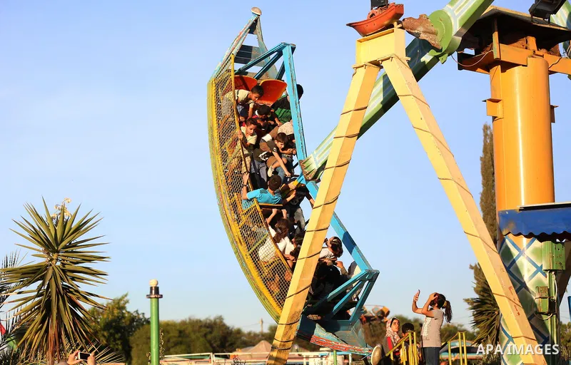 Palestinians take a ride at an amusement park on the third day of Eid al-Adha or the feast of sacrifice in Khan Younis in the southern of Gaza strip, on August 2, 2020. Muslims are celebrating Eid al-Adha (the feast of s...