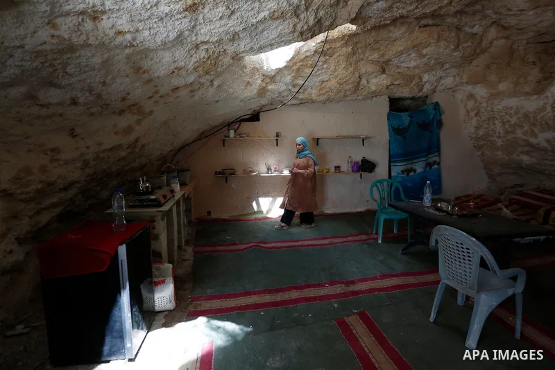The wife of Ahmed Amarneh, walks at the kitchen of his home which he built in cave, in the village of Farasin, west of Jenin, in the northern West Bank on August 11, 2020. Amarneh, a 30 year old civil engineer, lives wit...