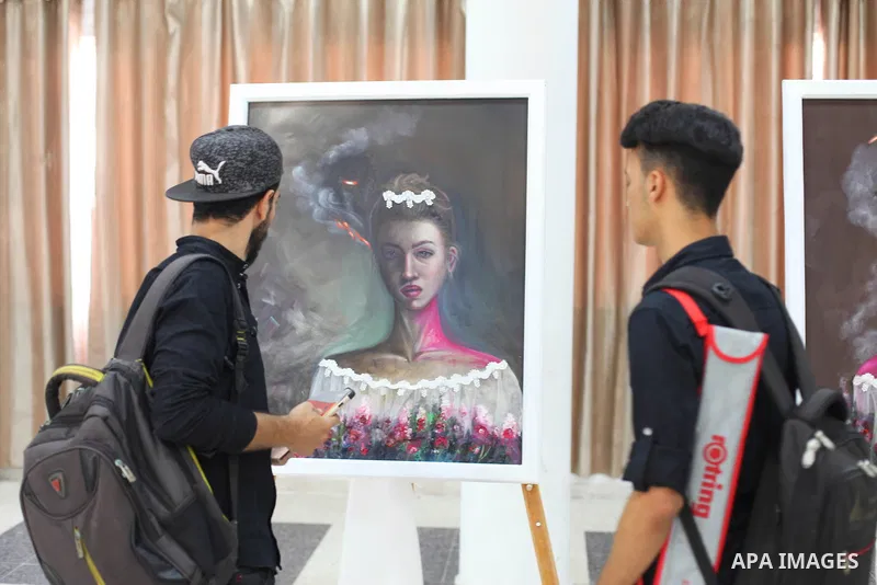 Palestinians visit the artist's exhibition Kholoud Al-Dessouki, 28, her two-day to reveal the violence against women through dozens of paintings on display in Gaza City on August 13, 2020. Photo by Mahmoud Ajjour